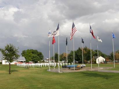 Lockney war memorial with a row of flags flying over rows of white crosses