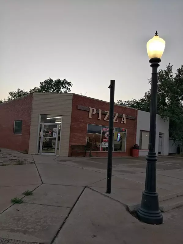 Main Street Pizza storefront at dusk with a street lamp